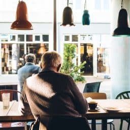 An older man sitting in a cafe.